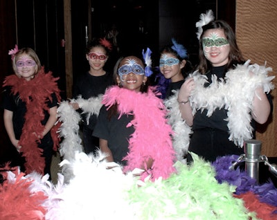 Children from the Y.M.C.A., who were decked out in multicolored feather boas and had Mardi Gras-style masks painted on their faces, greeted guests.