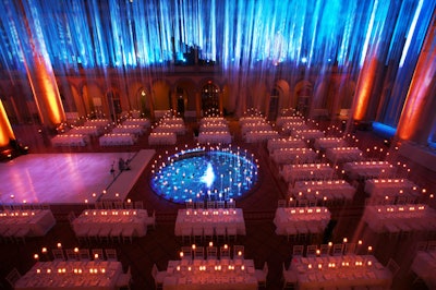 Tall votive candles dressed the blue-lit fountain and the long white-clothed banquet tables.