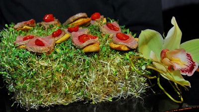 Passed hors d'oeuvres includd truffled lamb loin on a pita crostini served on a bed of alfalfa.