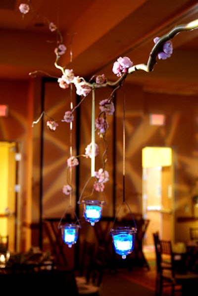 Large cherry blossom branches were suspended above each table with three candleholders dangling from satin ribbons.