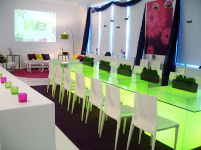 Illuminated green cubes formed the conference tables, which was surrounded by colorful rugs, candles, and draped fabric.