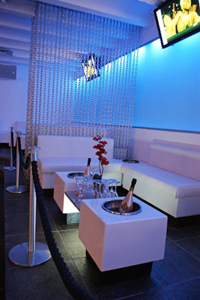 Chain-link divider curtains, white banquettes, and built-in bottle service tables lend a contemporary feel.
