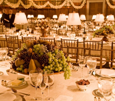 The centerpieces of leaves, pine cones, fruits, and beaded flowers sat in mahogany pedestal bowls.