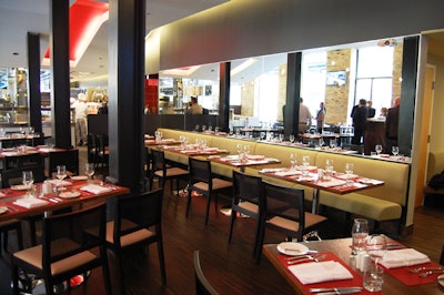The main dining room features chestnut wood tables, a mirrored wall, and red accents.