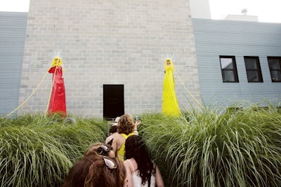 Shakespeare's Wild Sisters, artists in residence for the Watermill Center's summer benefit in the Hamptons, created an installation featuring two colorfully dressed women on towers who controlled human puppets that crawled in the grass beside the main entrance.