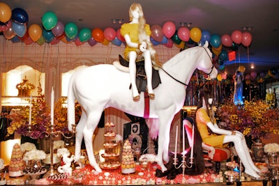 A horse, tiers of dessert trays, and two mannequins representing the company founders sat atop a 16-foot-long antique mirrored table.