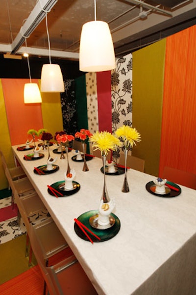 At the table McDonald's Corporate designed for MDC Wallcoverings, white porcelain hands held colored fortune cookies, and floral arrangements were placed in descending height order.