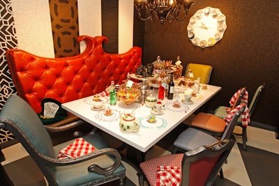 Mismatched chairs, tea pots, and oversize candy jars with signs that read 'eat me' channeled the Mad Hatter's tea party at Smith and Larkin Interior Design's table for MDC Wallcoverings.