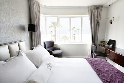 Guest rooms feature predominantly white decor with dark wood and decor accents.