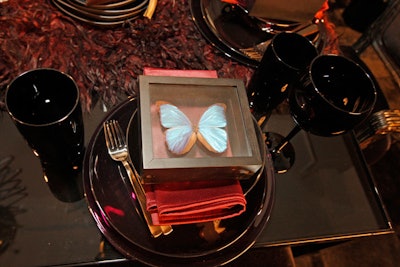 At the table that Jennifer Sweas created for CS Interiors, the iridescent wings of mounted butterflies offset silky, ruby-toned napkins.
