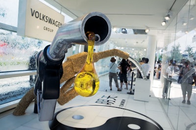 Above the Chinese symbol of yin and yang at the Volkswagen pavilion, a display showed a traditional gas pump with oil dripping from it and another spouting organics like water and plants.