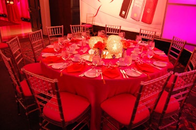 Bright fuchsia tablecloths and custom orange napkins decorated tables.