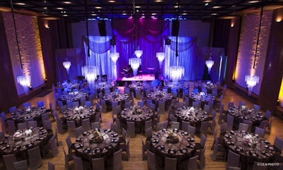 Donald Braun transformed the black-box theater with sparkling chandeliers, luxe linens, and amber and lilac lighting.