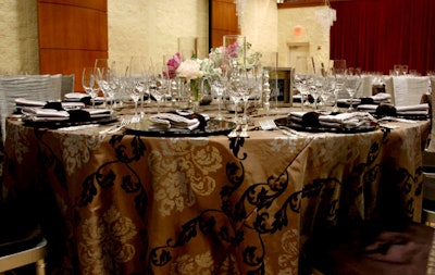 The tables were draped in mocha-colored satin linens embossed with a silver brocade and chocolate paisley pattern from Nuage Designs.