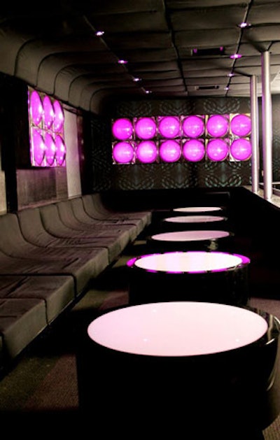 The lounge features metallic seating against a backdrop of colorful lighting.