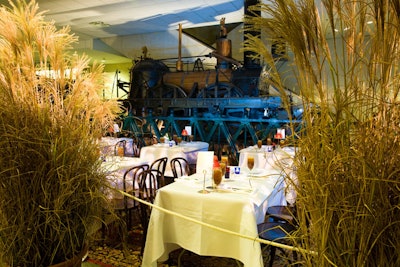 Pots of tall, ornamental grasses sheltered the train car-style dining area, positioned in front of an antique locomotive.