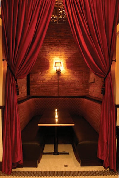 Red velvet drapes surround a private banquette at 1914.