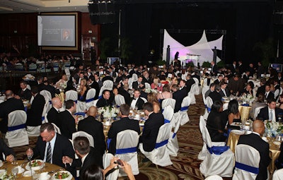 Gold cloths and orchid arrangements topped tables at the dinner.