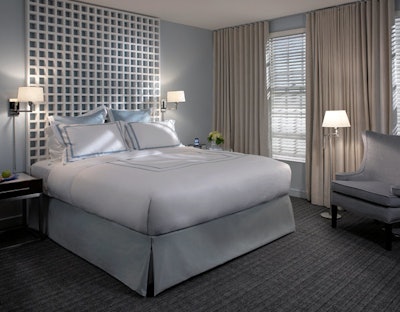 Guest room furnishings include custom wing chairs and trellis-style headboards.
