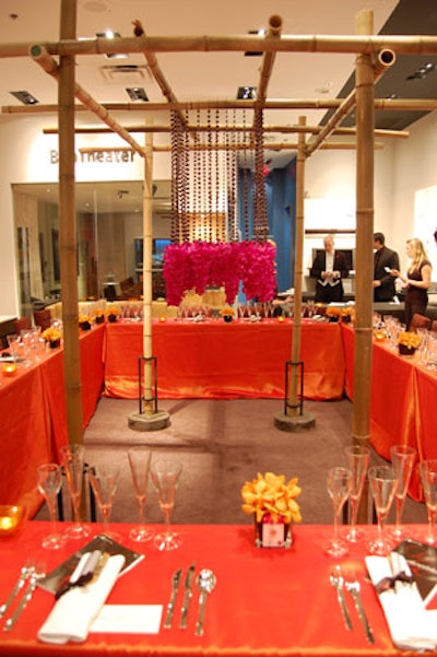 Pink flowers hung from black beads attached to a bamboo structure placed in the centre of the dining table at Bang & Olufson.