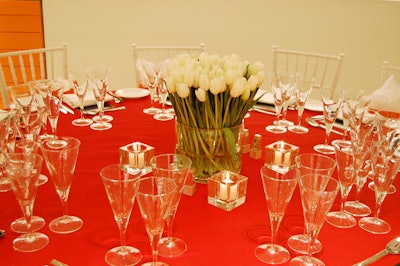 White tulips and orange linens topped tables for the dinner at Daniel Espinosa Studio.