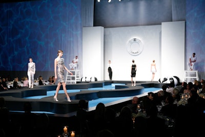 Models wearing items from Chanel's cruise collection walked a runway surrounded by a pool of water.
