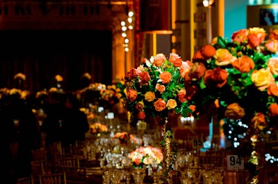 Floral designers raised alternating rose-filled centerpieces on ribbon-wrapped pedestals.
