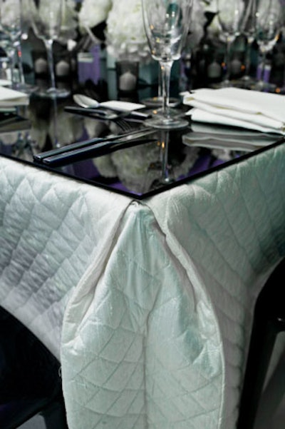 White quilted silk tablecloths and black lacquer squares topped the dinner tables.