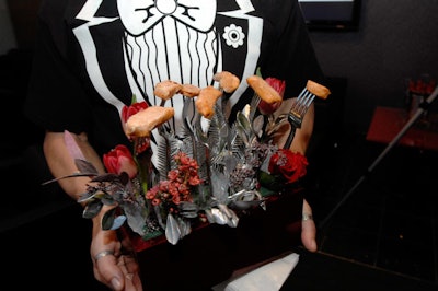 Ginger Island Cuisine served salmon stuck to forks placed in a planter with red roses and tulips.