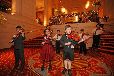 Young violinists from the Suzuki-Orff School of Music performed on the stairs leading up to the ballroom.