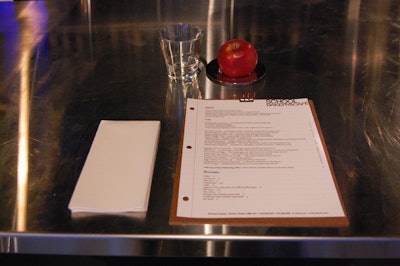 Single McIntosh apples on small silver saucers and clipboards holding menus sit along the counter and atop each table.