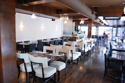 Cream and black leather chairs provide seating at dark wood tables throughout the space.