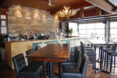 Two long tables beside the bar are made of reclaimed wood.
