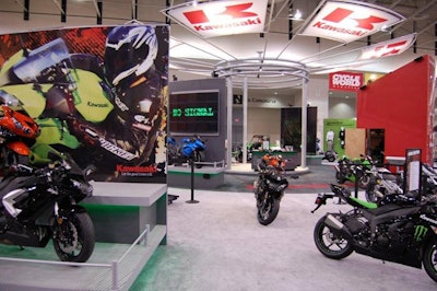 Kawasaki's exhibit included bold photos, a tubular steel tower with logo flags, and digital panels that showed their new model lineup.