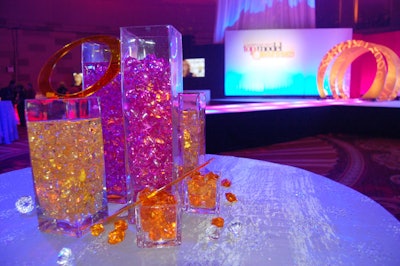Vases of plastic jewels and shards of colorful Plexiglas anchored each of the tables.