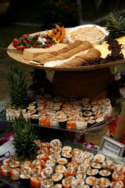 Chez Gourmet set up several hors d'oeuvre stations with items like brie drizzled with honey, crab and mango sushi rolls, and an assortment of crackers, cheeses, and fresh fruit.