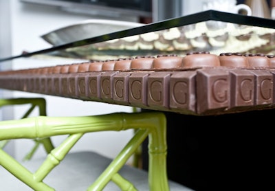 In imitation of Jonathan Adler's Bargello collection, hundreds of individual chocolates form a mosaic beneath the glass top of the dining table.