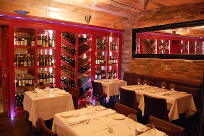 A hot pink wine cellar runs the length of the semiprivate dining room.