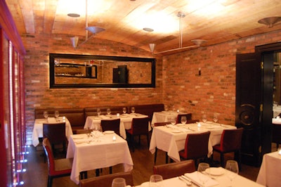 The new semiprivate dining room features exposed brick walls and a ceiling made of reclaimed wood.