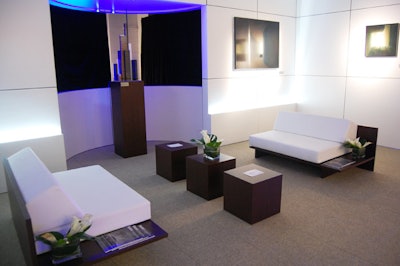 The lounge area featured white leather seating, dark wood accents, and several works by Canadian painter Dimitri Papatheodorou.