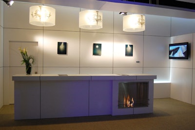 Three Phillipe Starck-inspired light fixtures hung above a long white bar that housed an eco-friendly fireplace.