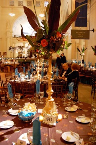 The Flower Firm crowned some dinner tables with towering centerpieces.
