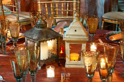 Rustic lanterns and votives cast a soft light on the dinner tables.
