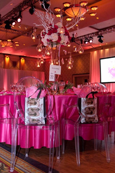 Ghost chairs surrounded tables draped in hot pink floor-length linens.