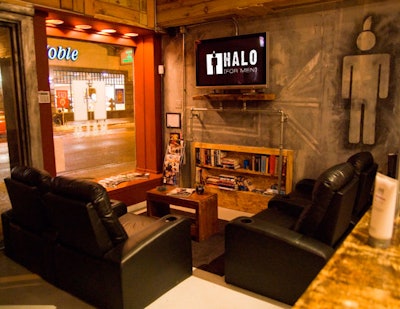 The waiting area at Halo for Men features four reclining theater chairs and a flat-screen TV that broadcasts movies and sports.
