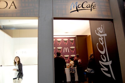 The signature red and yellow of McDonald's are absent from the fast-food chain's lounge in the tent. Instead, muted colors dominate the booth, and images of coffee cups decorate the walls.