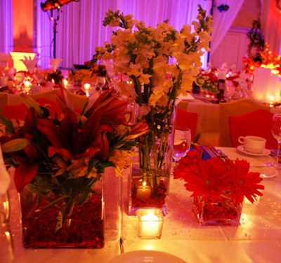 A collection of colorful flowers arranged in multiple vases of varying sizes and shapes topped each table.