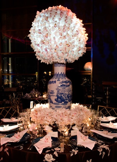 An illuminated orb of white orchids dominated the top of a massive vase at the table designed by Darren Henault Interiors Inc.