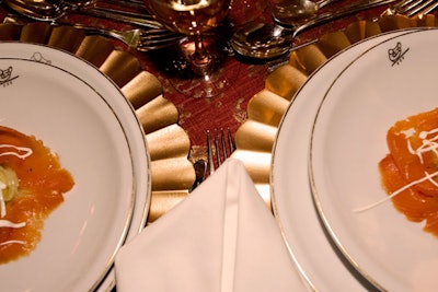 Interior designer David Easton used decorative golden chargers at each place setting.