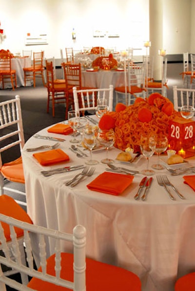 Rounds of ten covered in crisp white linens filled the orange gallery.